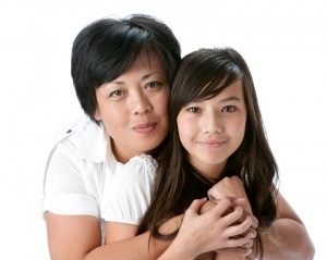 Real People: Head Shoulders Smiling Asian Mother Hugging Teenage